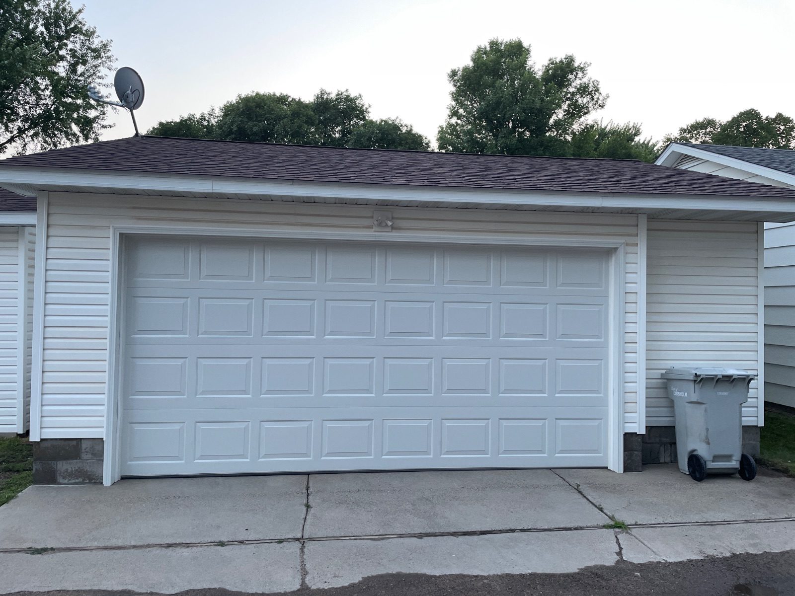 Clean asphalt shingle roof and white siding on a garage after soft washing, Chisholm, Minnesota