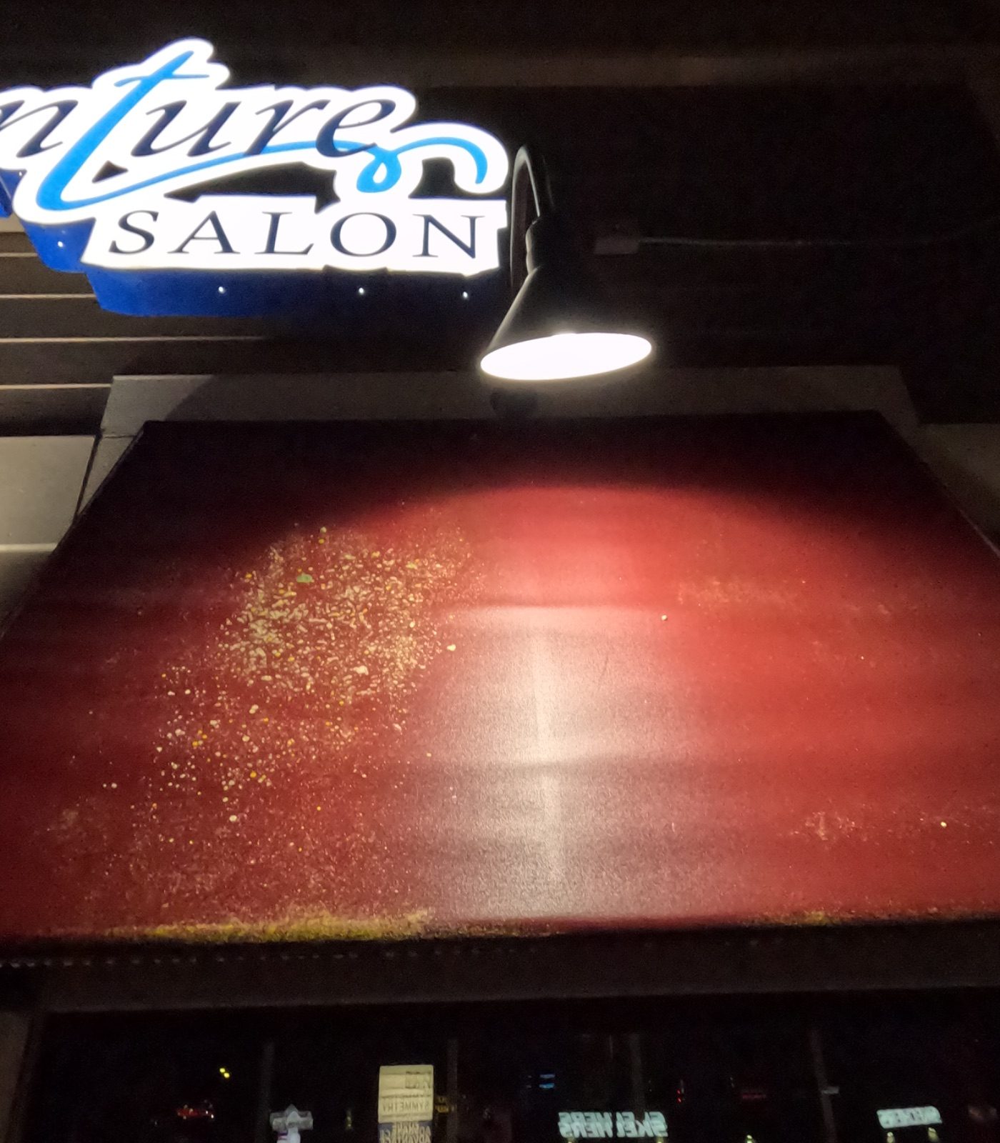 Salon storefront awning covered in algae and debris before cleaning, Hermantown MN